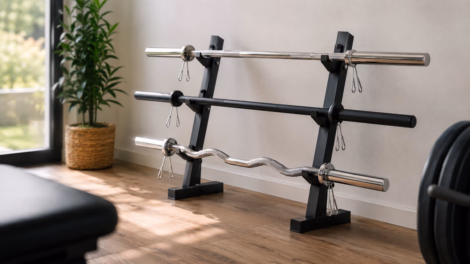 Barras de musculação de tipos diferentes — reta maciça, body pump e barra W — apoiadas num rack numa home gym iluminada